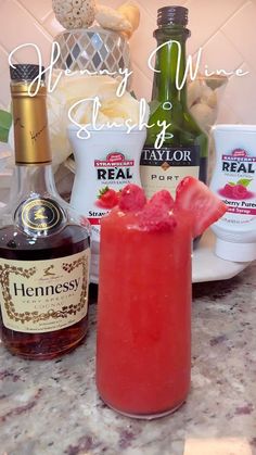 a red drink sitting on top of a counter next to bottles