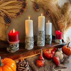 candles are sitting on a mantle with fall decorations