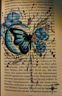 an open book with blue butterflies and flowers on it