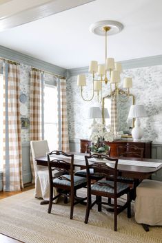 a dining room table with four chairs and a chandelier hanging from the ceiling