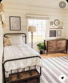 a bedroom with white walls and wood floors