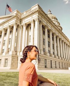 a woman sitting on the ground in front of a building