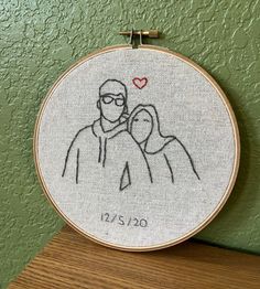 a hand embroidered portrait of two people with a heart