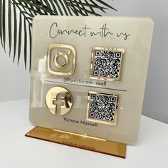 a white and gold plaque with qr - code on it that says connect us