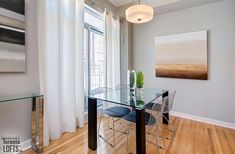 a dining room table with chairs and a painting on the wall