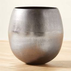 a silver vase sitting on top of a wooden table