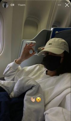 a person wearing a face mask while sitting in an airplane