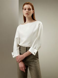 Featuring a sleek boat neckline, three-quarter sleeves, and a relaxed fit, this blouse exudes a sense of casual elegance. The French cuff detailing adds a touch of sophistication, while the custom carved horn buttons and the texture of the diagonal twill silk fabric enhances its sharp and polished silhouette. Silk Twill White Silk Blouse, Statement Blouse, Cape Style, Custom Carved, French Cuff, Fitted Blouses, Silk Twill, Boat Neckline, Silk Crepe