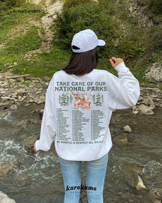 "This Unisex crewneck sweatshirt features \"Take Care Of Our National Parks | Be Mindful & Respect All Wildlife\" with a complete list of the 63 National Parks in the U.S. and a gorgeous watercolor forest illustration on the back and front. This sweater is perfect for raising awareness about adventuring responsibly as well as being a unique U.S. National Park bucket list! Make sure to check out the other garment options below :) » O P T I O N S « ‣ Hoodie: https://www.etsy.com/listing/1346786720 Crew Neck Sweater With Letter Print For Outdoor, Crew Neck Letter Print Sweater For Outdoor, Long Sleeve Letter Print Sweater For Outdoor, White Crew Neck Sweatshirt For Outdoor Activities, Outdoor Letter Print Sweatshirt Crew Neck, Outdoor Crew Neck Sweatshirt With Letter Print, White Graphic Print Sweatshirt For Outdoor Activities, Long Sleeve Letter Print T-shirt For Outdoor Activities, Long Sleeve T-shirt With Letter Print For Outdoor Activities