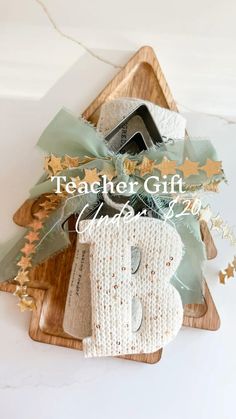 a wooden tray holding a christmas tree shaped gift box with scissors and other items in it