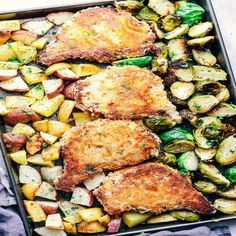 chicken, potatoes and brussels sprouts in a baking pan on a blue towel