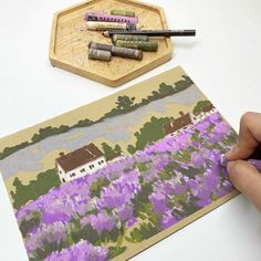 someone is painting flowers with crayons on paper