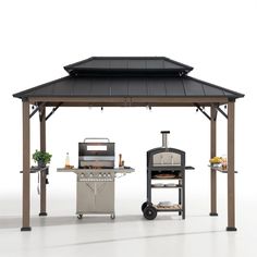 an outdoor kitchen with grill, oven and table on the ground in front of it