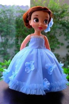 the doll is wearing a blue dress with flowers on it