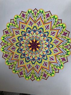 a drawing of a colorful flower on white paper