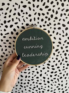 a person holding up a blackboard with writing on it that says, ambiton earning leadership