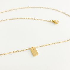 A minimalistic and dainty way to showcase your initial of choice. Wear your initial or someone else's in style by layering or wearing solo. Coated in 18k gold and crafted from high quality stainless steel for a tarnish free and water resistant finish. Dainty Initials Charm Necklace With Square Pendant, Dainty Charm Necklaces With Initials On Square Pendant, Minimalist Initial Necklace With Delicate Chain, Minimalist Yellow Gold Charm Necklace With Rectangular Pendant, Classic Rectangular Initial Necklace, Dainty Rectangular Initial Necklace, Minimalist Rectangular Charm Necklace, Minimalist Rectangular Initials Jewelry, Minimalist Initial Pendant Charm Necklaces