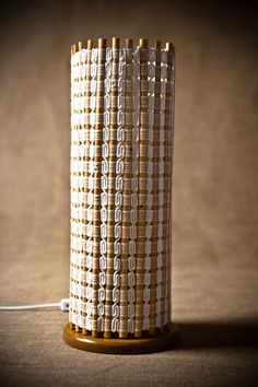 a lamp made out of bamboo sticks on top of a brown tablecloth covered floor