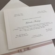 a white wedding card on top of an envelope