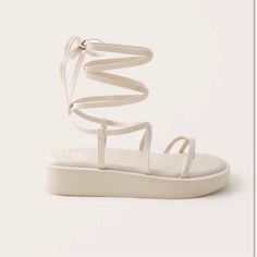 Fits Like 7.5/8. Cute Neutral Strappy Sandal. Never Worn Summer Flat Platform Lace-up Sandals, Flat Platform Lace-up Sandals For The Beach, White Platform Lace-up Sandals For Summer, White Flat Lace-up Sandals For Vacation, White Platform Lace-up Sandals For The Beach, White Round Toe Lace-up Sandals For Vacation, White Lace-up Sandals With Round Toe For Vacation, Cream Closed Toe Sandals For Summer, White Synthetic Lace-up Sandals For Summer