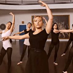 a group of women in black leotards and white tops are doing ballet moves