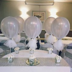 the tables are set up for a wedding reception with silver sequins and white balloons