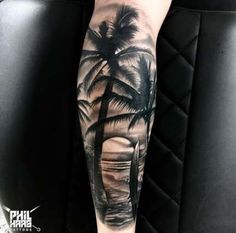 a man's arm with a palm tree tattoo on it