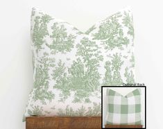 a green and white pillow sitting on top of a wooden shelf