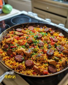 a pan filled with rice and sausage on top of a stove