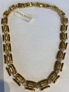 Nina Ricci Necklace. Triple 22kt gold w handset Swarovski crystals. Designer, Vintage, Canadian. 18 inches long 1/2 inches wide Gold Hallmarked Necklaces For Evening, Classic Gold Necklace With Sparkling Stones, Elegant Gold-tone Rhinestone Jewelry, Elegant Yellow Gold Necklace With Rhinestones, Gold Necklaces With Diamond Accents For Evening, Formal Gold Crystal Necklaces, Formal Yellow Gold Rhinestone Necklaces, Luxury Rhinestone Necklaces For Formal Occasions, Gold Necklace With Diamond And Rhinestones