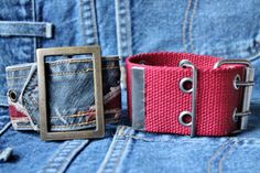 two pieces of cloth with metal buckles on them sitting in the pocket of a pair of jeans