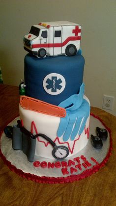 a medical themed cake on a table with an ambulance and doctor's stethoscope