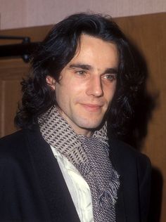 a man with long black hair wearing a scarf