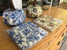 three pieces of fabric sitting on top of a wooden table next to pumpkins and other decorative items