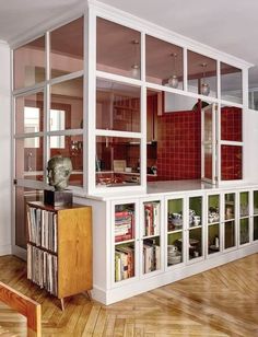 a room filled with lots of books on top of a hard wood floored floor