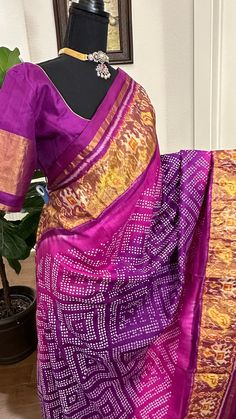 Expertly handwoven with pure zari, this Purple Patola Silk Bandhani Saree is a stunning addition to any wardrobe. Adorned with intricate bandhani patterns, this saree is a perfect blend of traditional and modern style. Comes with a stitched blouse for a complete and hassle-free look. Perfect for any occasion. Purple patola  silk  with  gold pallu with stitched blouse beautiful border. DETAILS AND CARE Colour : purple Weight : 600 - 800 grams Length : 5.5 m saree + 0.7 m blouse Width : 48 Inches Fabric : patola pure silk Craft Description : patola Wash Care : Dry Wash Only Shipping Time : 5 - 7 Working days We Ship Worldwide Comes with prestitched blouse size 36 goes up to 42 very beautiful high quality   silk saree  https://admin.shopify.com/store/shruthis-sarees/articles/559483519167   SH Festive Ikat Print Saree For Traditional Ceremonies, Fitted Ikat Print Saree For Festivals, Multicolor Bandhani Print Traditional Wear In Slub Silk, Ikat Print Choli For Festivals With Traditional Drape, Traditional Ikat Print Choli For Navratri, Festive Silk Saree With Ikat Print, Traditional Drape Choli With Ikat Print For Festivals, Traditional Ikat Print Choli For Festivals, Traditional Drape Ikat Print Choli For Festivals