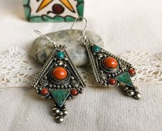 Gift idea ! Ethnic and elegance! A very beautiful pair of earrings made of Tibetan silver, turquoise and Natural Coral. This pair of earrings is inspired by traditional Tibetan jewelry, a unique model! They will accompany your outfits in a vintage boho ethnic style. Very nice quality. They are mounted on 925 silver. Length under attachment: 5 cm Weight of an earring: 9 g They are shipped with a small traditional fabric pouch and tips. Shipping will be fast and careful. Visit the NEPALMASHOP.FR store for more choices in Nepalese and Tibetan jewelry and beads. Namaste! Traditional Turquoise Earrings With Natural Stones, Bohemian Turquoise Earrings With Intricate Design, Turquoise Bohemian Earrings With Intricate Design, Tibetan Jewelry, Fabric Pouch, Natural Coral, Traditional Fabric, Ethnic Earrings, Coral Turquoise