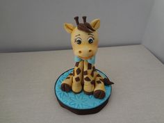 a toy giraffe sitting on top of a blue plate