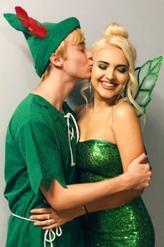 a man and woman dressed up as tinkerbells kissing on the cheek while standing next to each other