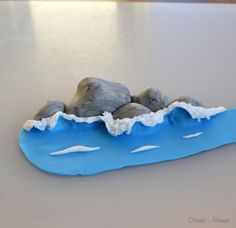 a toothbrush sitting on top of a blue plate with rocks and water in it