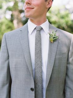 a man wearing a suit and tie with a boutonniere on his lapel