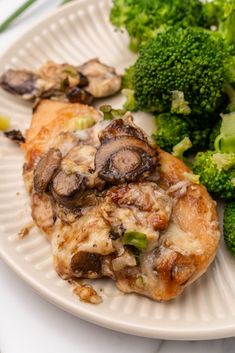 a white plate topped with chicken and broccoli