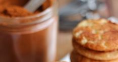 there is a stack of pancakes on the plate next to a jar of powdered sugar