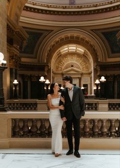 a bride and groom standing in an ornate building