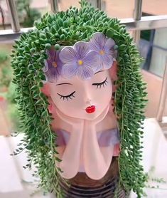 a woman with flowers in her hair is sitting on a window sill next to some plants