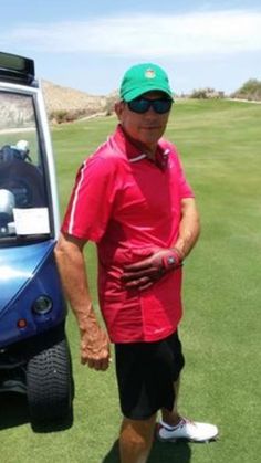 an older man standing next to a golf cart