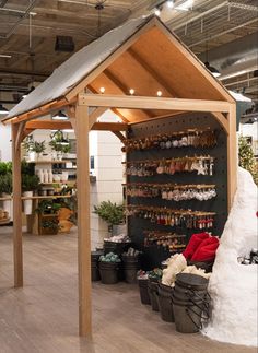 the inside of a store with lots of plants and snow on the floor, including an umbrella