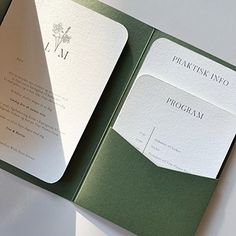 an open green and white wedding card with the wording on it's side