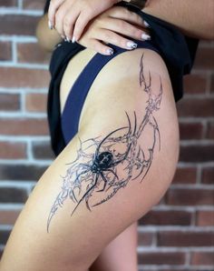 a woman's thigh with a spider tattoo on it