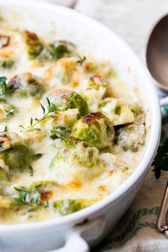 a casserole dish with broccoli, cheese and other vegetables in it